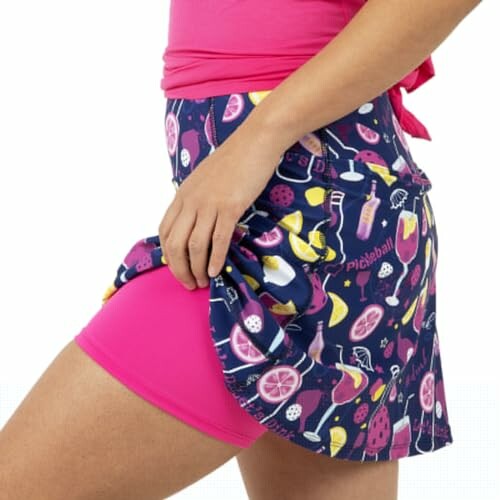 Person wearing a colorful pickleball-themed skirt with pink shorts underneath.