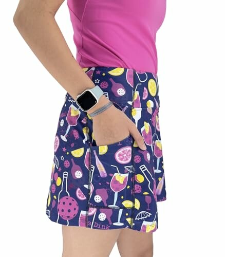 Person wearing a colorful pickleball-themed skirt with pink shorts underneath.