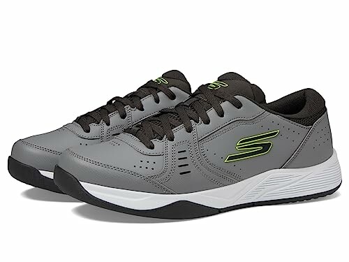 Gray sneakers with black laces and green accents.