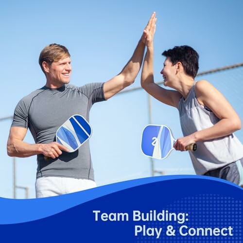 Two people high-fiving while playing pickleball, promoting team building.