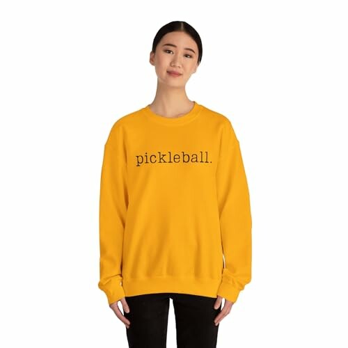 Person wearing a yellow sweatshirt with 'pickleball' text